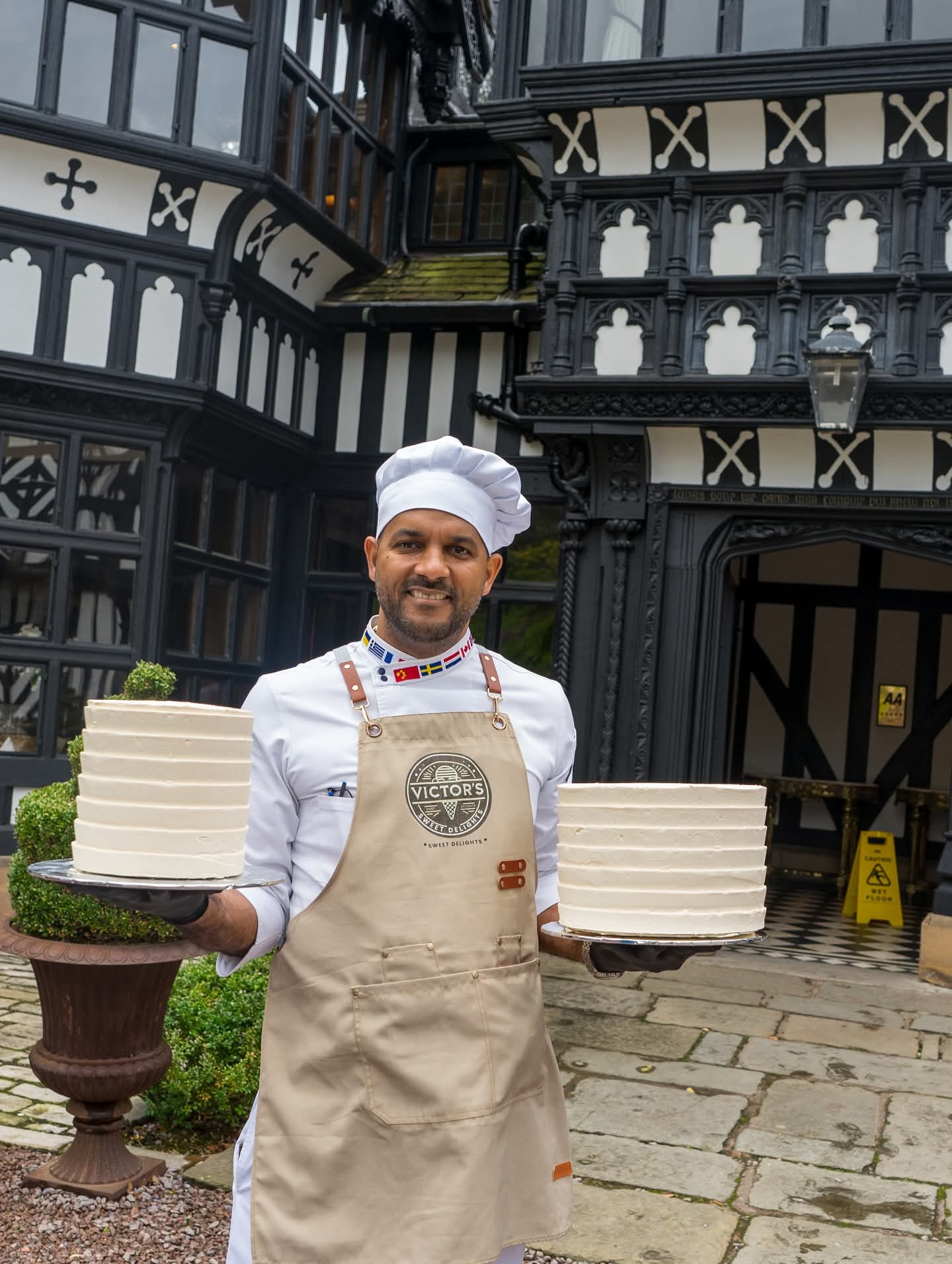 Chef Victor holding two white celebration cakes